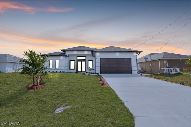 view of front of property with a yard and a garage