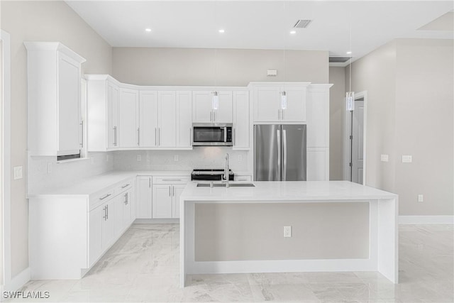 kitchen featuring white cabinetry, sink, an island with sink, and appliances with stainless steel finishes