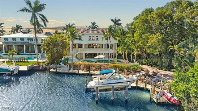 back of property with a water view and boat lift