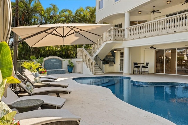 outdoor pool featuring ceiling fan, stairway, and a patio