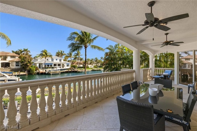 balcony featuring a water view and a ceiling fan