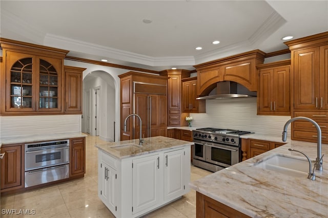 kitchen with a warming drawer, a sink, high quality appliances, and brown cabinets