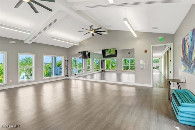 unfurnished living room with ceiling fan, lofted ceiling with beams, and wood-type flooring