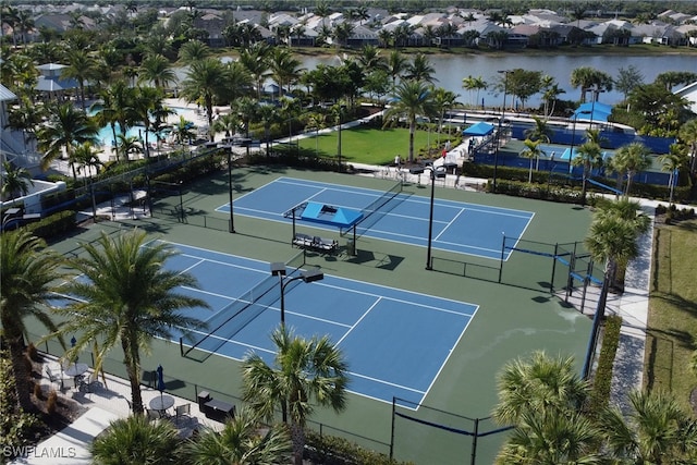 view of tennis court with a water view