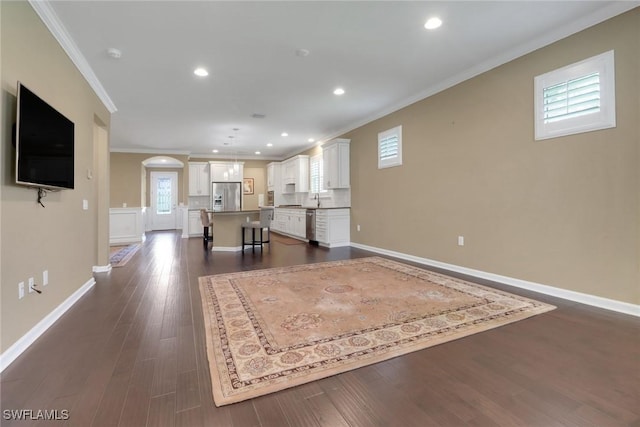 unfurnished living room with dark hardwood / wood-style flooring, ornamental molding, and sink