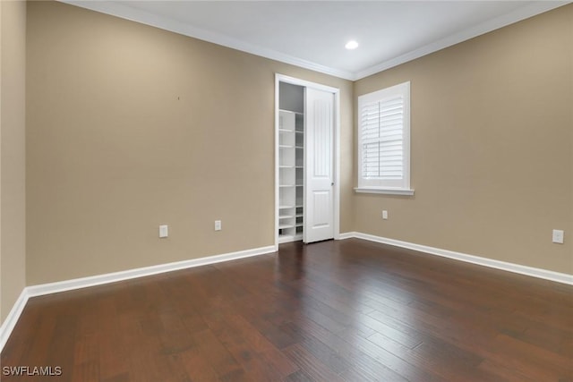 empty room with ornamental molding and dark wood-type flooring