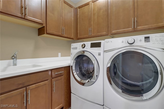 laundry room with sink, separate washer and dryer, and cabinets