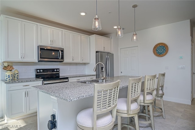 kitchen with sink, stainless steel appliances, a kitchen island with sink, and white cabinets