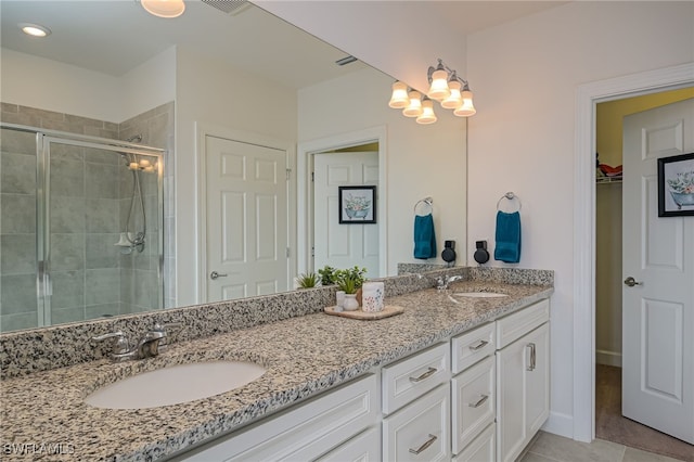 bathroom featuring tile patterned floors, vanity, and a shower with door