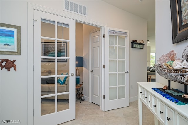 entryway with light tile patterned floors and french doors