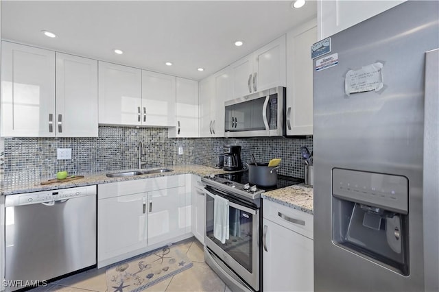 kitchen featuring white cabinetry, appliances with stainless steel finishes, sink, and light tile patterned floors