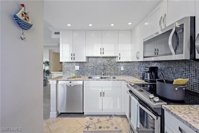 kitchen featuring light stone countertops, appliances with stainless steel finishes, sink, and white cabinets