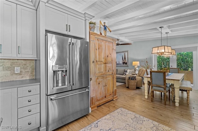 kitchen featuring beam ceiling, decorative backsplash, high quality fridge, hanging light fixtures, and light wood-style floors