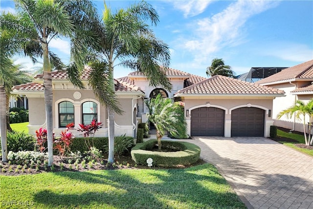 mediterranean / spanish-style home with a garage and a front lawn