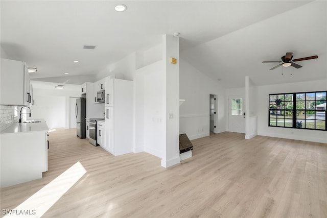 unfurnished living room featuring ceiling fan, high vaulted ceiling, sink, and light hardwood / wood-style floors