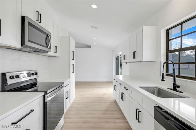 kitchen featuring stainless steel appliances, sink, white cabinets, and light hardwood / wood-style floors