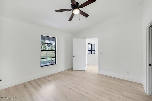 spare room with light hardwood / wood-style flooring, vaulted ceiling, and ceiling fan