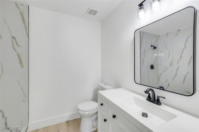 bathroom featuring vanity, wood-type flooring, toilet, and walk in shower