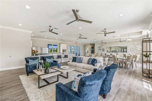 living room with ornamental molding and light hardwood / wood-style floors