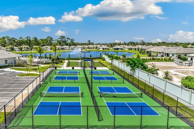 view of tennis court with a water view