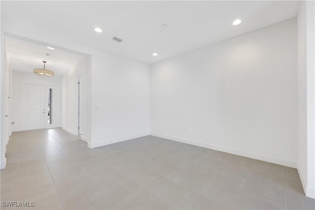 empty room with visible vents, recessed lighting, and baseboards