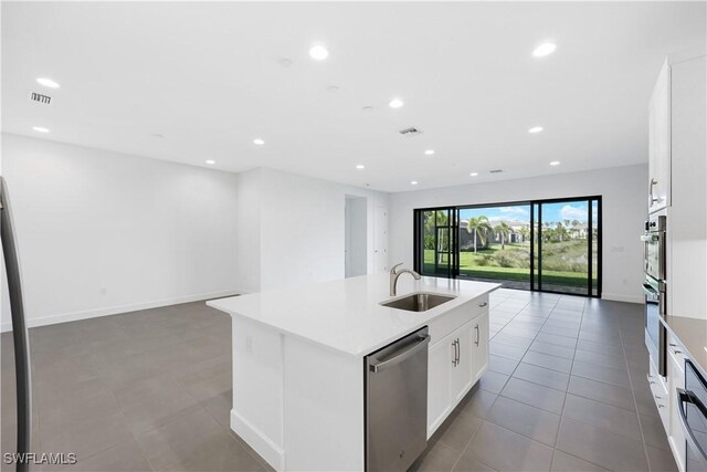 kitchen featuring a sink, dishwasher, open floor plan, and recessed lighting