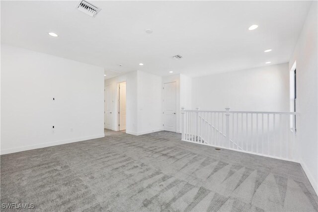 empty room featuring visible vents, recessed lighting, baseboards, and carpet floors