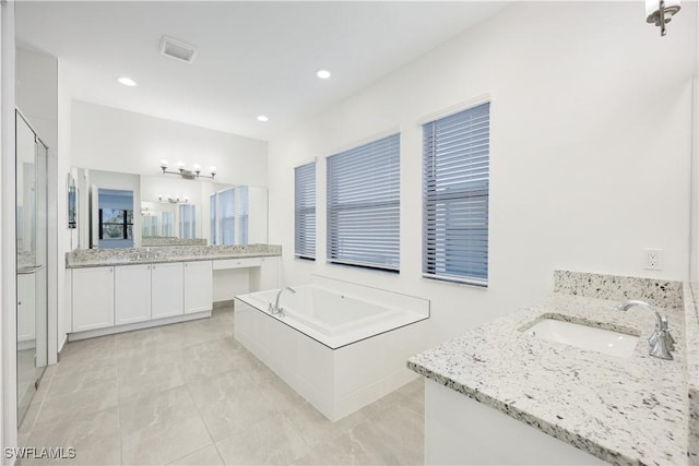 bathroom with two vanities, recessed lighting, a stall shower, a sink, and a bath