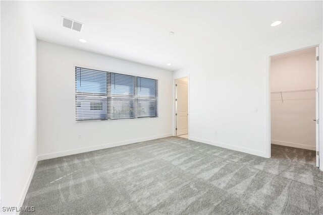 carpeted empty room featuring recessed lighting, baseboards, and visible vents