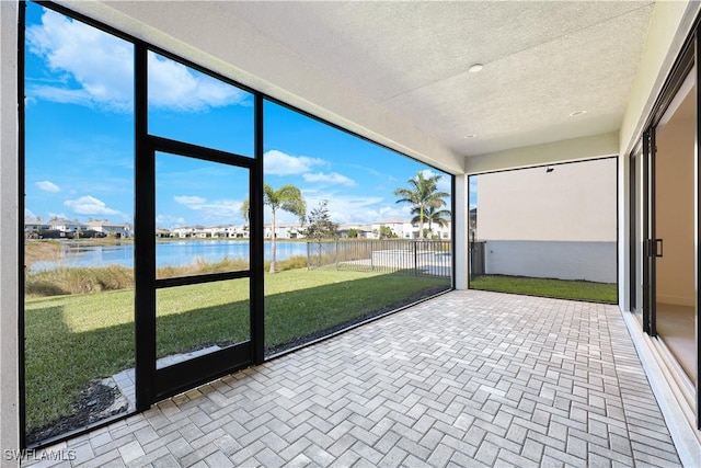 unfurnished sunroom featuring a water view