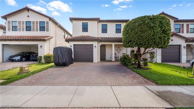 mediterranean / spanish-style home featuring a garage and a front lawn