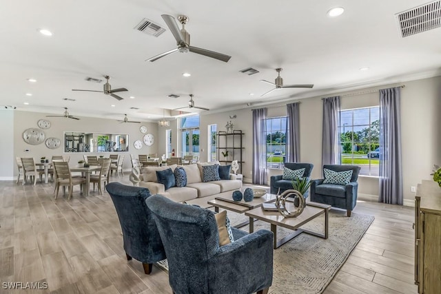 living room featuring crown molding and light hardwood / wood-style flooring