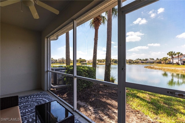 unfurnished sunroom with a water view and ceiling fan