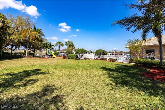 view of yard featuring fence and playground community