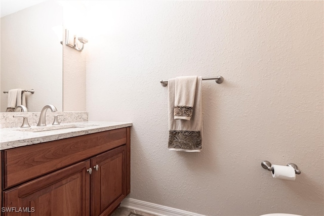 half bathroom featuring vanity and baseboards