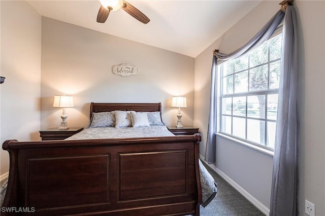 carpeted bedroom featuring baseboards, vaulted ceiling, and a ceiling fan