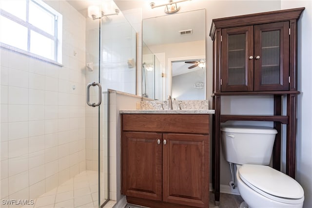 bathroom with toilet, a stall shower, vanity, and visible vents