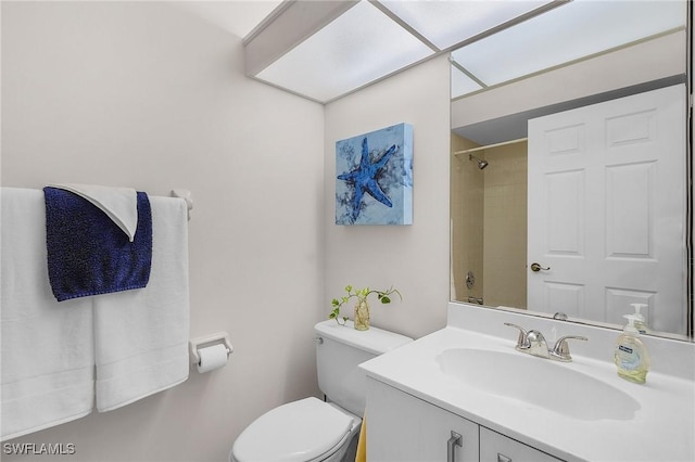 bathroom with vanity, a tile shower, and toilet