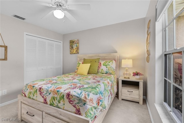 carpeted bedroom featuring ceiling fan and a closet