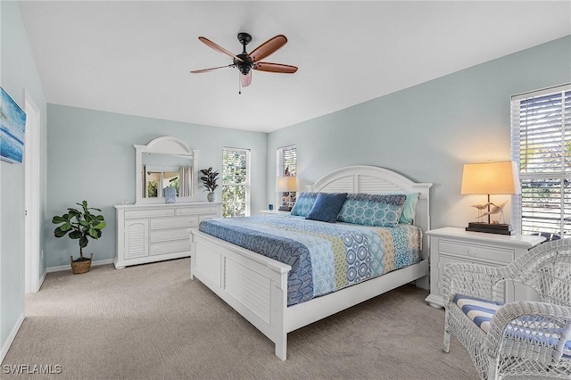 carpeted bedroom featuring multiple windows and ceiling fan