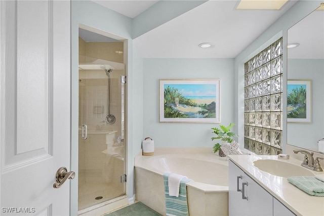 bathroom featuring shower with separate bathtub and vanity