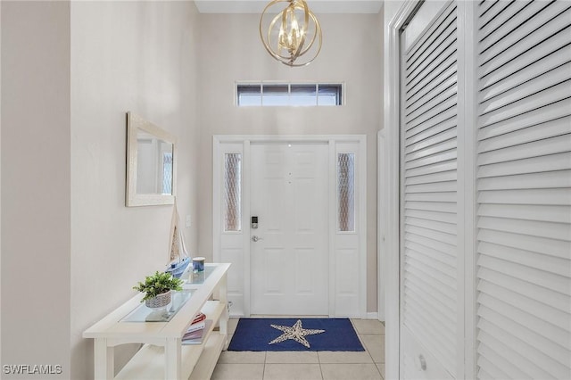 tiled entryway with a notable chandelier