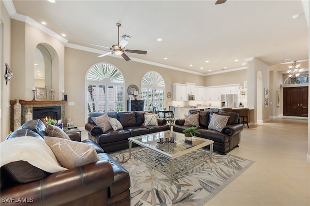 living area with recessed lighting, visible vents, baseboards, ornamental molding, and a glass covered fireplace