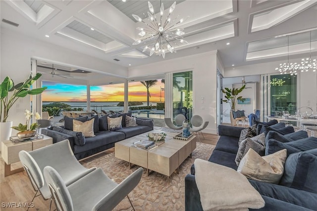 living room featuring light wood finished floors, coffered ceiling, visible vents, and an inviting chandelier