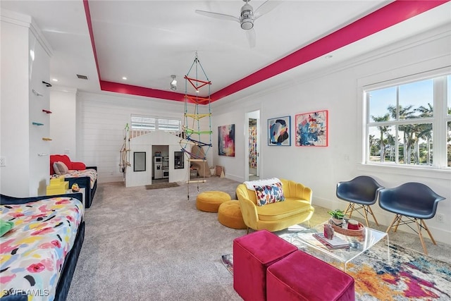 carpeted living room with a tray ceiling, visible vents, ceiling fan, and baseboards