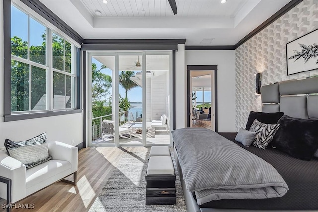 bedroom featuring recessed lighting, wood finished floors, access to exterior, ornamental molding, and a raised ceiling