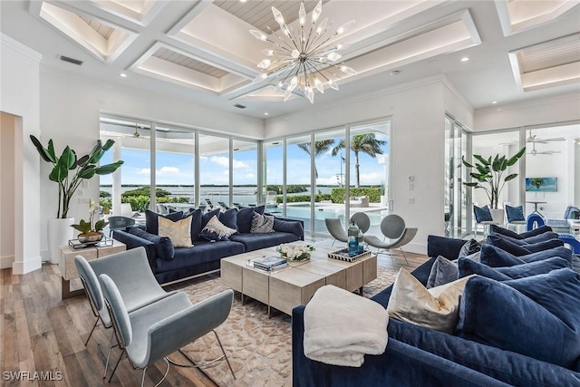 living room featuring a chandelier, plenty of natural light, coffered ceiling, and light wood-style floors