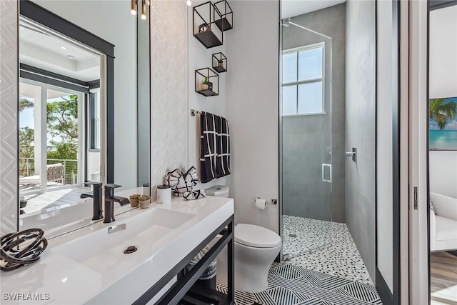 full bathroom with toilet, a tile shower, and vanity