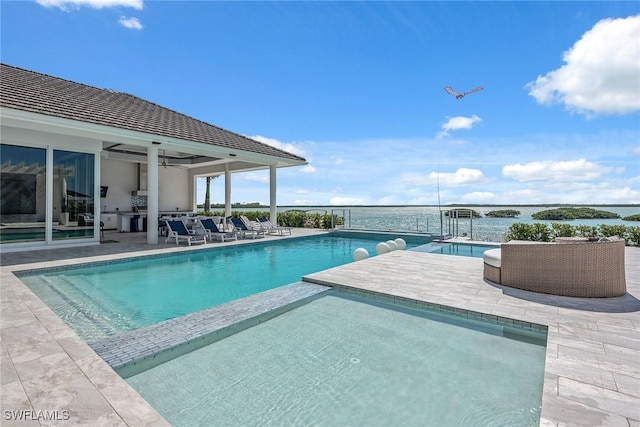 view of pool featuring a pool with connected hot tub, a patio, and ceiling fan