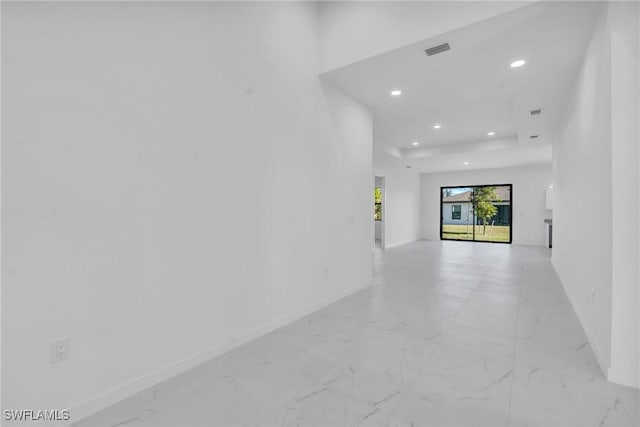 spare room featuring marble finish floor, baseboards, and recessed lighting